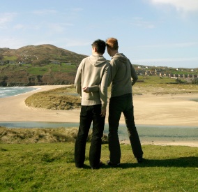 Two boys standing by the beach